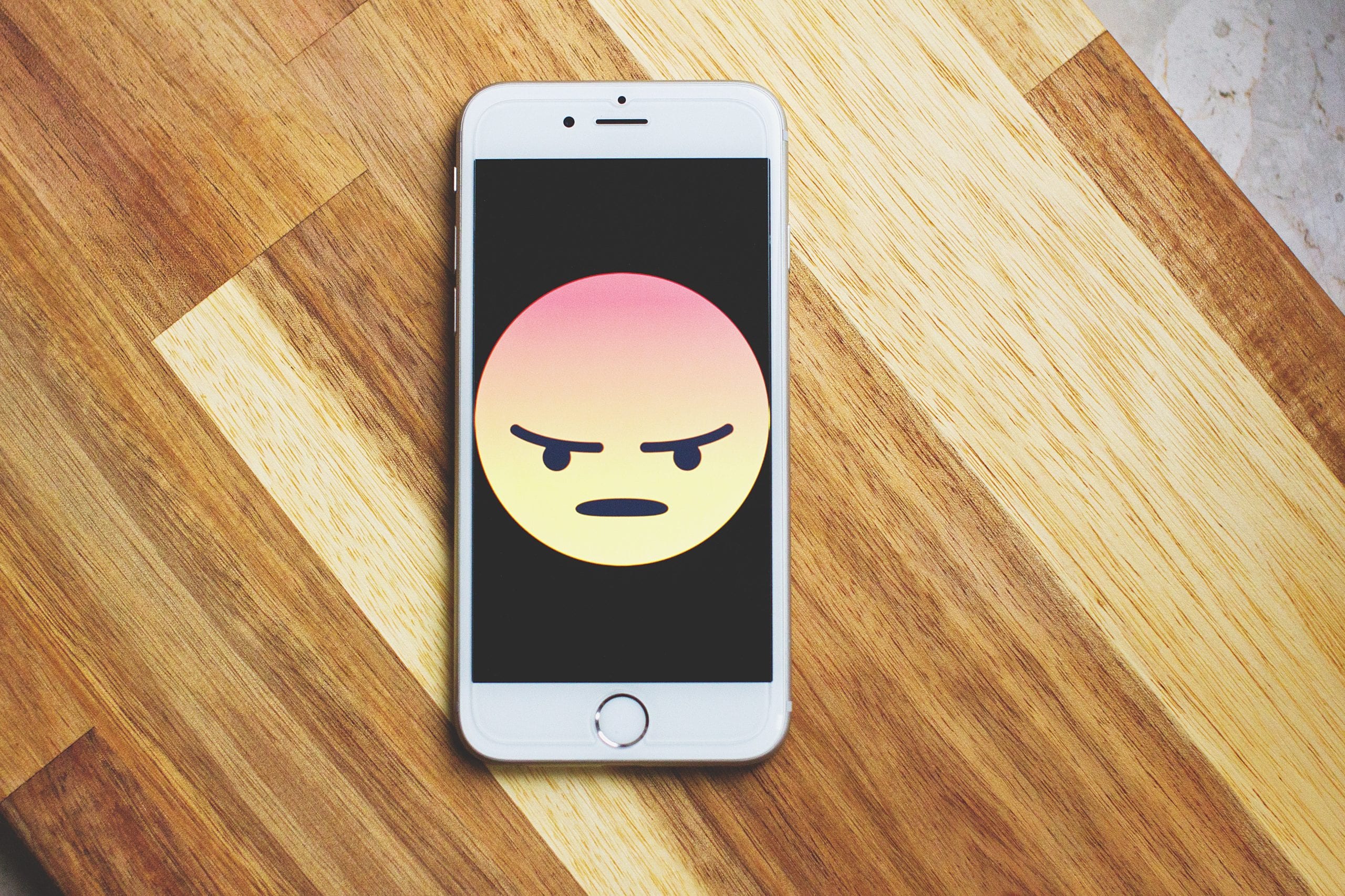 Angry emoji displayed on a phone