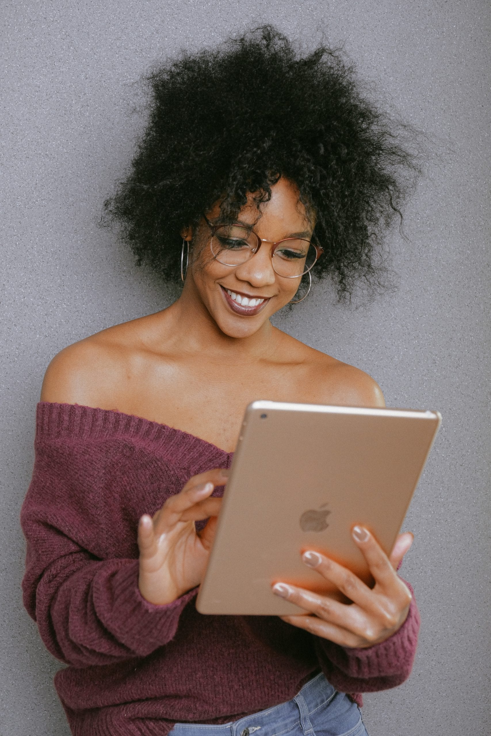 A woman cheerfully reading content on her tablet
